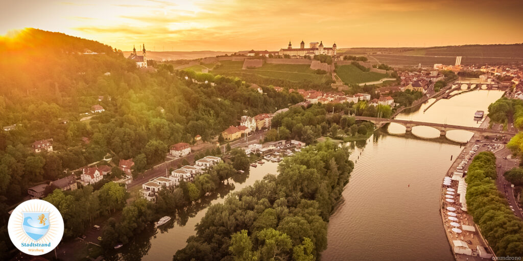 Luftaufnahme von Würzburg mit Blick auf den Main, die Alte Mainbrücke und die Festung Marienberg im goldenen Abendlicht-